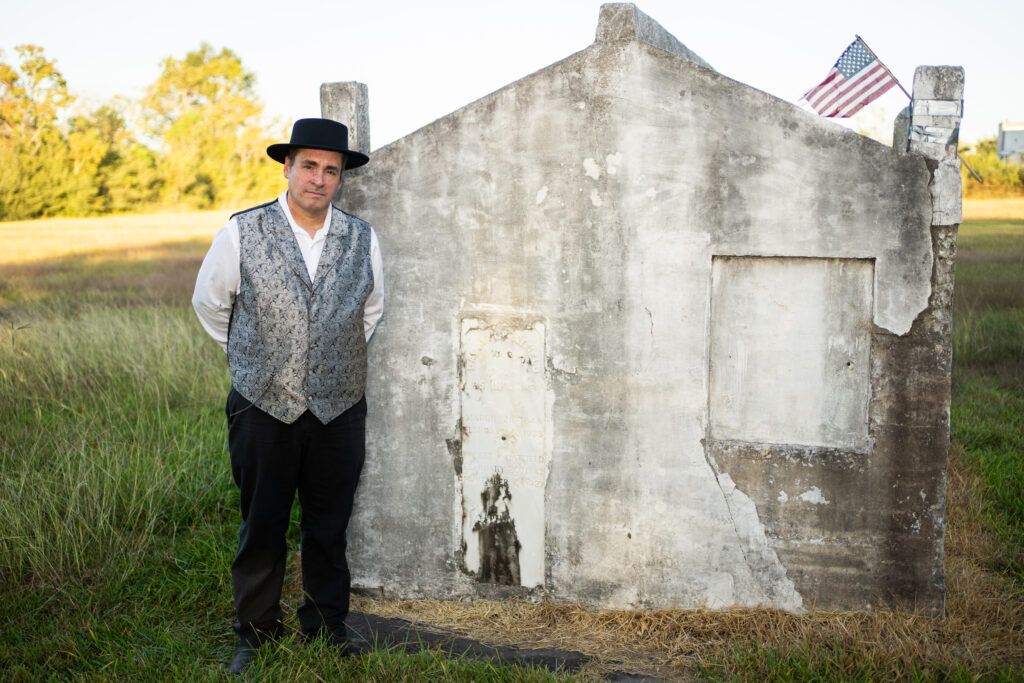 Actor from the Pearl Theater poses near mausoleum in Old Settlers Cemetery in Pearland during Hops and History event